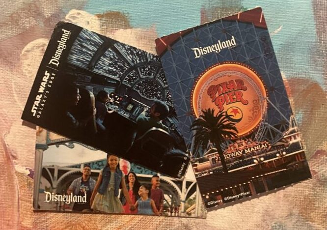 Paper tickets for entry to Disneyland Park and Disney California Adventure Park at Disneyland Resort in California. Showing image of guests, Pixar Pier and Star Wars: Galaxys Edge.
