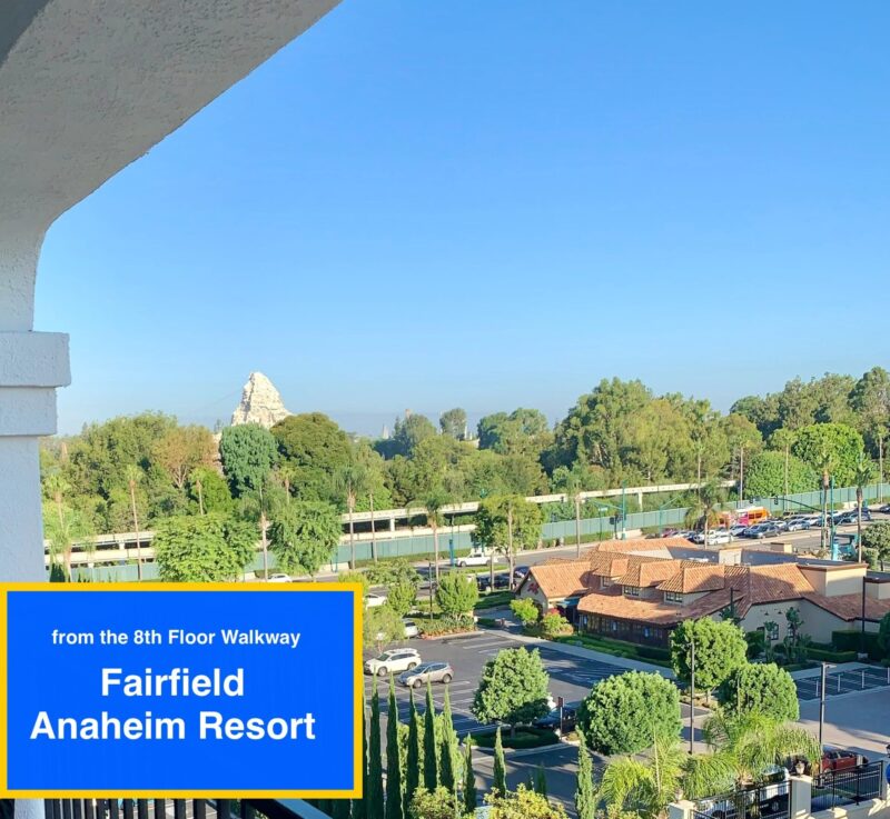 View from the 8th floor outdoor walkway Fairfield Anaheim Resort by Marriott near Disneyland showing monorail track, trees, Star Wars Black Spires rock work and Matterhorn Mountain at Disneyland Park.