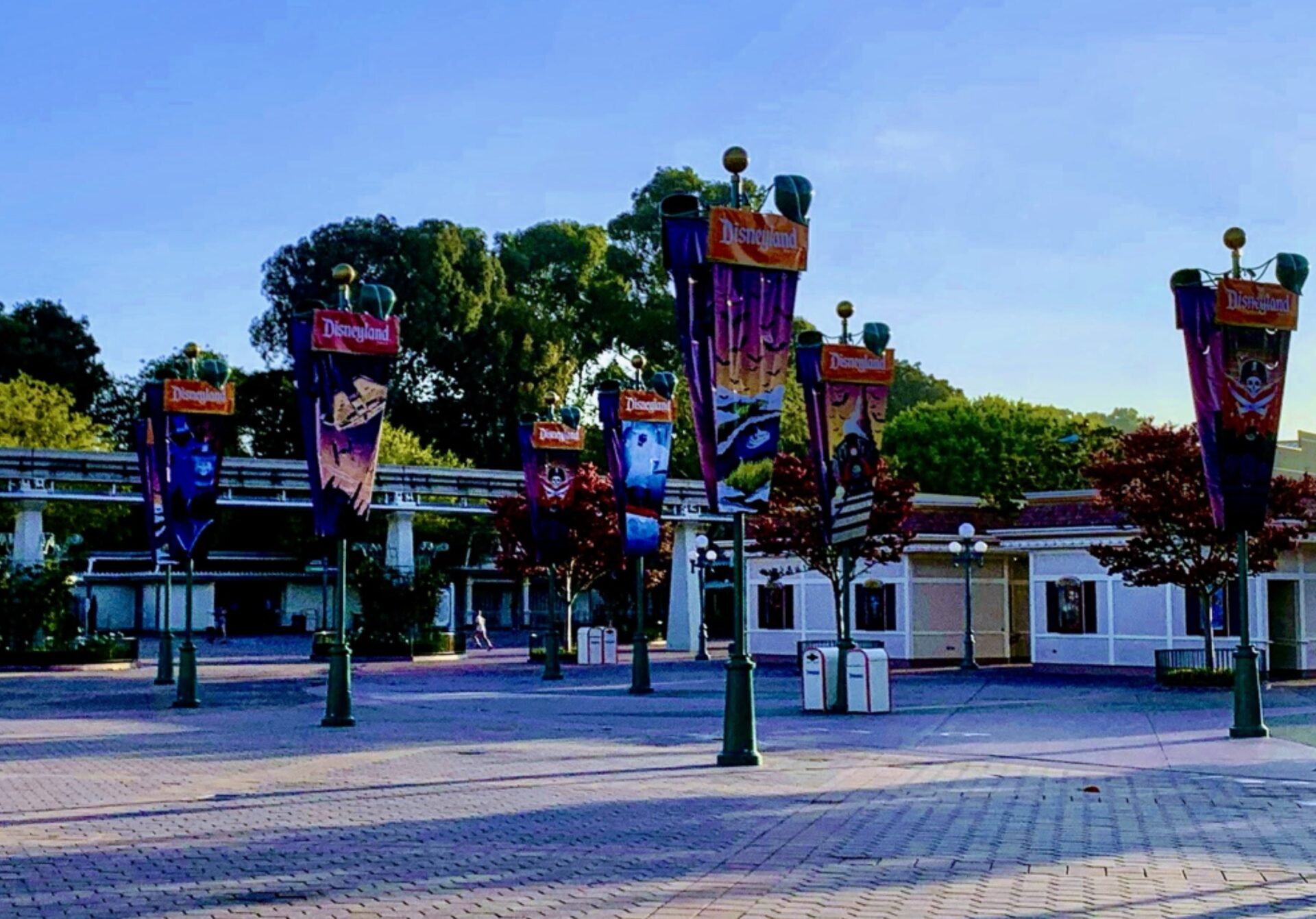 Photo of entrance plaza Esplanade between Disneyland Park and Disney California Adventure Park in Disneyland Resort in Anaheim, California. Illustrates that guests can enter the Disneyland Esplanade without an admission ticket and shows seasonal decor with Halloween banners.