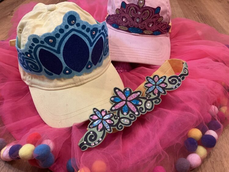Items we use to comfortably dress like a princess art Disneyland including soft stretchy tiaras on baseball caps and tutus with pom poms