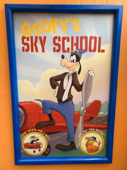 Photo of an attraction post at Disney California Adventure Park at Disneyland Resort. This framed poster shows Goofy posing next to an airplane in pilots attire. The text says “Goofy’s Sky School”