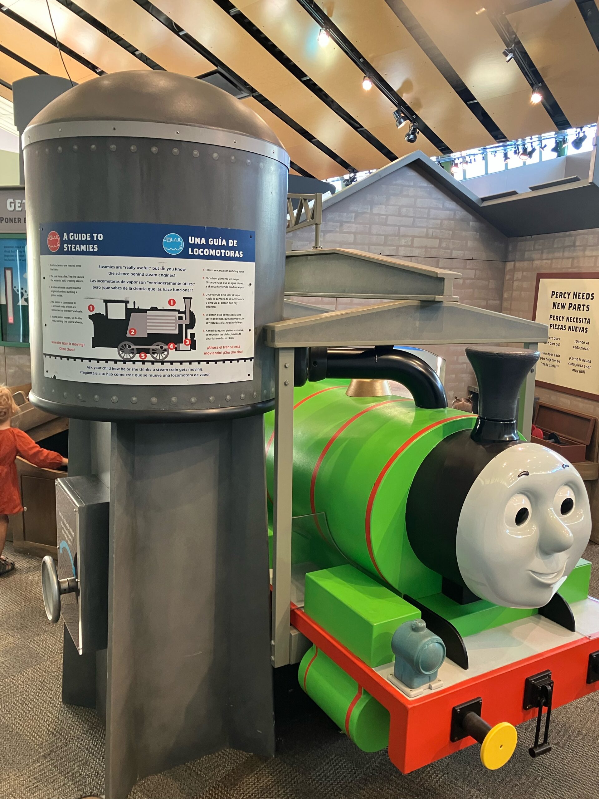 Percy engine beside water tower in Sodor Steamworks at Thomas & Friends: Explore the Rails at Kohl Children’s Museum near Chicago.