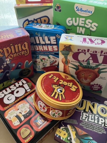 Bundle of small travel card games for a trip to Disneyland. Games are Sleeping Queens, Skip-Bo, Guess in 10, Mille Bournes, Rat-a-Tat Cat, Sushi Go!, Spot It! and Uno Flip!