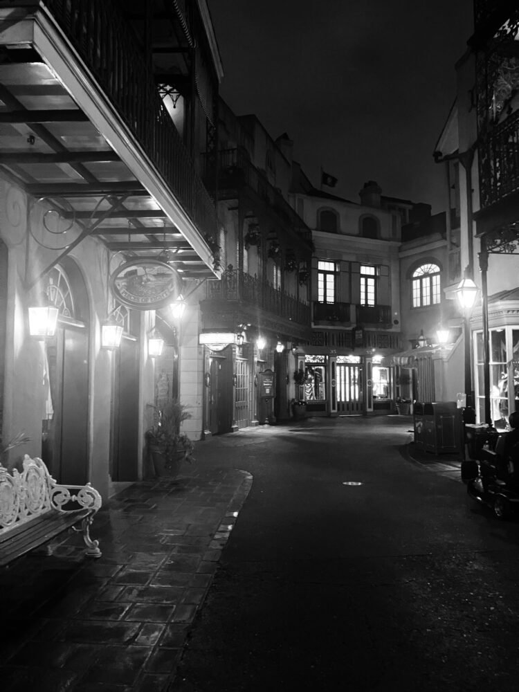 Photo showing street in New Orleans Square in Disneyland Park. Shows shops along curving street.