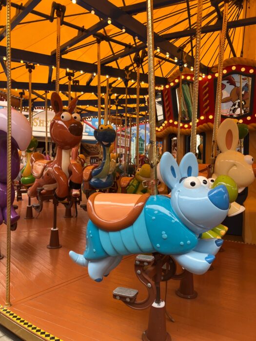 Photo from Jessie’s Critter Carousel at Disney California Adventure Parl. Photo shows popcorn lights on roof over cartoonish characters including a rabbit, armadillo and deer.